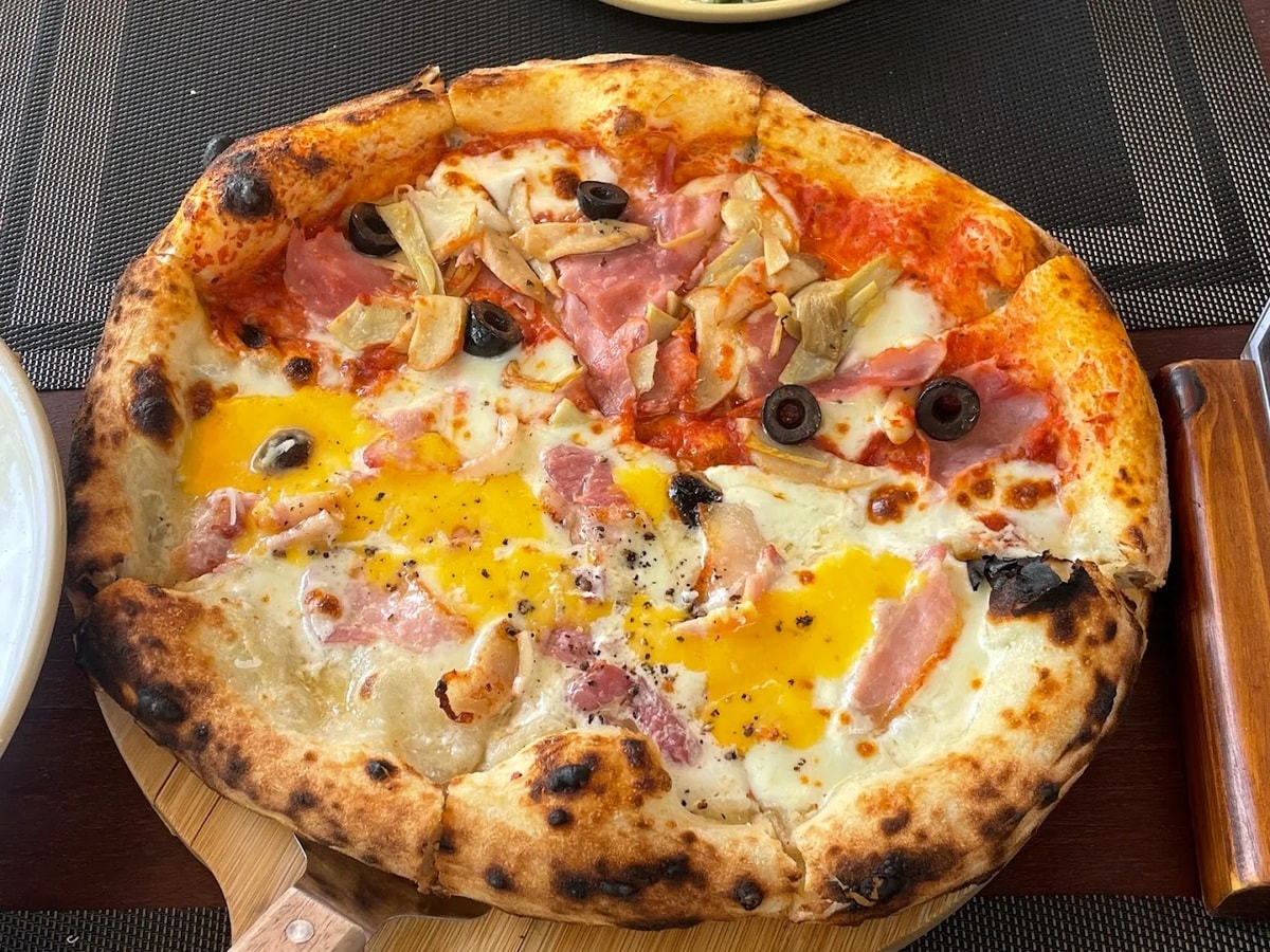 Generously topped pizzas with various cheeses, bacon, and mushrooms are highly rated by many diners 